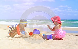 Kids play with sand on summer beach