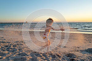 Kids play with sand on summer beach. Happy child boy playing in the sea. Kid having fun outdoors. Summer vacation