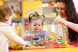 Kids play with shapes and colorful wooden puzzle in a montessori classroom