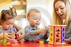 Kids play with shapes and colorful wooden puzzle in a montessori classroom