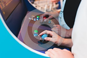 Kids play slot machine at amusement theme park, children play arcade gaming machine, racing and shooting game at the fair,