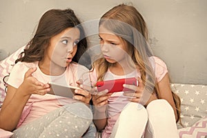 Kids play smartphone mobile game application. Smartphone application concept. Girlish leisure pajama party. Girls