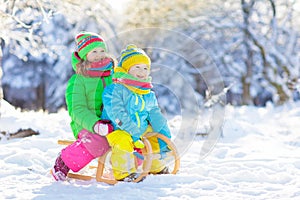 Kids play in snow. Winter sled ride for children