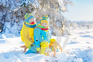 Kids play in snow. Winter sled ride for children