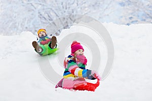 Kids play in snow. Winter sled ride for children