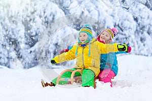 Kids play in snow. Winter sled ride for children