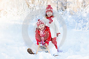 Kids play in snow. Winter sleigh ride for children