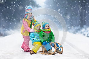 Kids play in snow. Winter sleigh ride for children