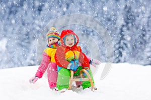 Kids play in snow. Winter sleigh ride for children