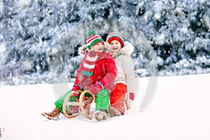 Kids play in snow. Winter sleigh ride for children