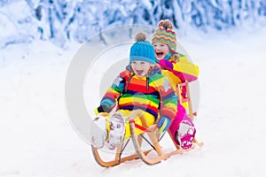 Kids play in snow. Winter sleigh ride for children