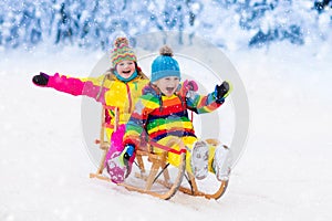 Kids play in snow. Winter sleigh ride for children