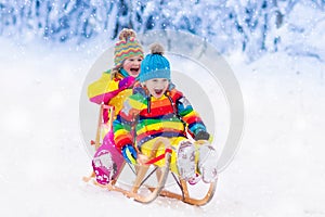 Kids play in snow. Winter sleigh ride for children