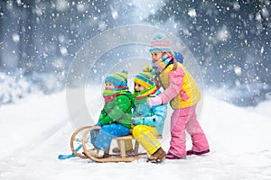 Kids play in snow. Winter sleigh ride for children