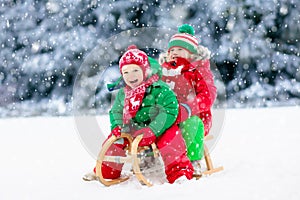 Kids play in snow. Winter sleigh ride for children