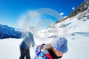 Kids play snowball active winter game in mountains