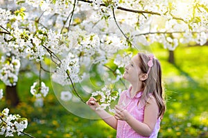 Kids play in spring park. Little girl with flowers