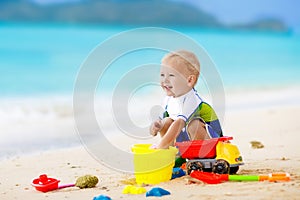 Kids play on tropical beach. Sand and water toy.