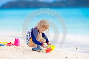 Kids play on tropical beach. Sand and water toy.