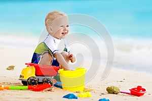 Kids play on tropical beach. Sand and water toy.