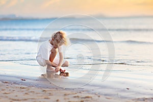 Kids play on tropical beach. Sand and water toy