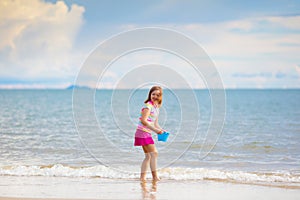 Kids play on tropical beach. Sand and water toy