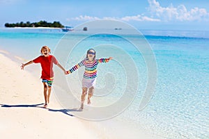 Kids play on tropical beach. Sand and water toy