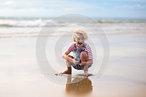 Kids play on tropical beach. Sand and water toy