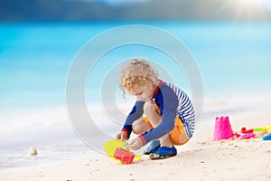 Kids play on tropical beach. Sand and water toy.