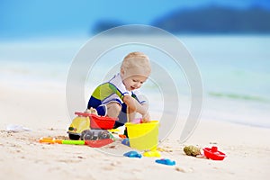 Kids play on tropical beach. Sand and water toy.