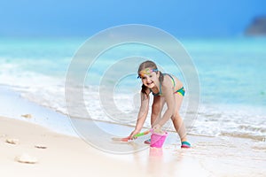 Kids play on tropical beach. Sand and water toy.