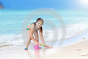 Kids play on tropical beach. Sand and water toy.