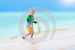 Kids play on tropical beach. Sand and water toy.