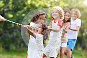 Kids play tug of war. Children pull rope