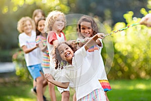 Kids play tug of war. Children pull rope