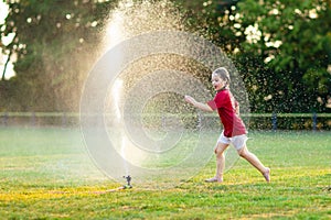 Kids play with water. Child with garden sprinkler