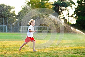 Kids play with water. Child with garden sprinkler