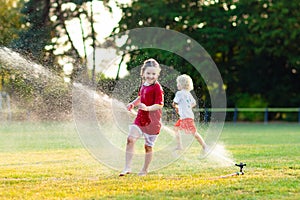 Kids play with water. Child with garden sprinkler