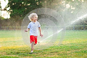 Kids play with water. Child with garden sprinkler