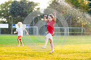 Kids play with water. Child with garden sprinkler