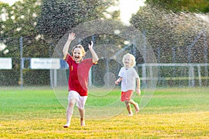 Kids play with water. Child with garden sprinkler