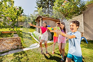 Kids play water gun fight in a team with friends