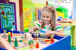 Kids play wooden railroad. Child with toy train