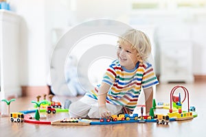 Kids play wooden railway. Child with toy train