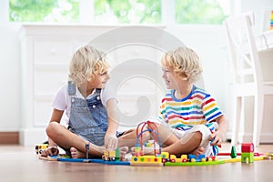 Kids play wooden railway. Child with toy train