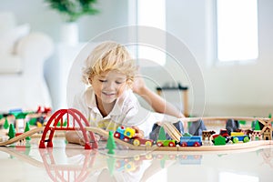 Kids play wooden railway. Child with toy train