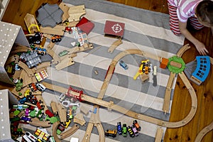 Kids play with wooden railway. Child with toy train. Cute kid playing cars and engine. Educational toys young children