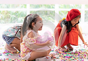 Kids playing with balloons and throwing paper in kid party