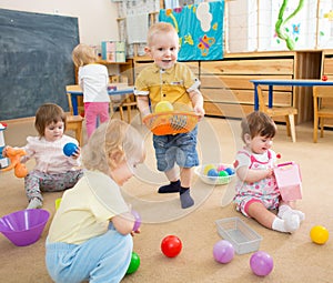 Kids playing with balls in kindergarten room