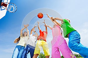 Kids playing basketball with a ball up in sky